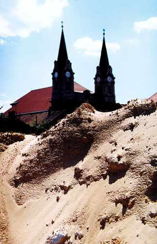 The building site with the long line towers of the church of St. Andrew in the background