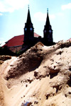 The building site with the long line towers of the church of St. Andrew in the background