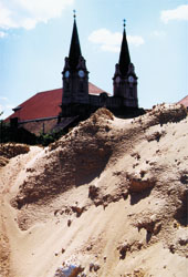 Az építkezés területe, háttérben a Szent András-templom karcsú tornyai